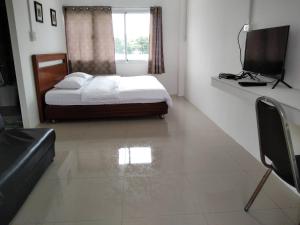坤西育府Armthong Resort的一间卧室设有一张床、一个窗口和一台电视