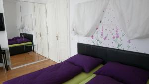 维也纳佐维娜酒店 - 市中心公寓的一间卧室配有紫色的床和鲜花墙