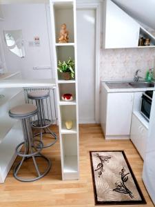 新瓦罗什Apartman Slavica的一个带两个凳子和水槽的小厨房