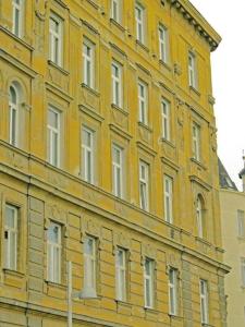 维也纳佐维娜酒店 - 市中心公寓的一座大型黄色建筑,有很多窗户