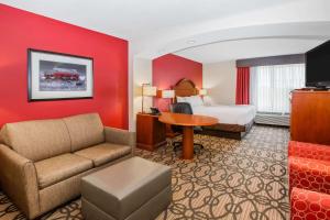 北普拉特北普拉特拉金塔旅馆及套房       的酒店客房配有一张床、一张沙发和一张书桌。
