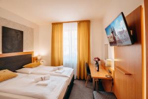 捷克布杰约维采克利卡酒店的酒店客房设有两张床、一张桌子和一台电视。