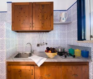 法维尼亚纳米拉马雷公寓式酒店的厨房柜台设有水槽和一碗水果