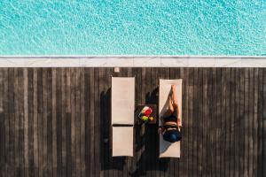 佩里沃罗黑玫瑰海滩套房酒店的游泳池边的比基尼女人