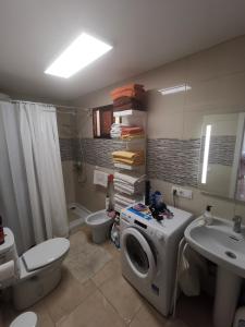 阿德耶Comfort的一间带洗衣机和水槽的浴室