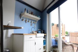 Woerdense VerlaatFroukje's B&B的厨房设有蓝色的墙壁和白色的橱柜。