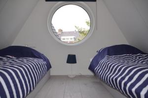 Woerdense VerlaatFroukje's B&B的带圆窗的客房内的两张床