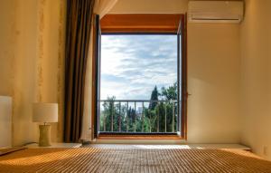 波德戈里察阿托斯公寓式酒店的一间卧室设有美景大窗户