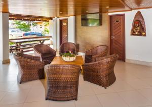 塞古罗港Quinta do Sol Lite Praia Hotel的一间带桌子和藤椅的用餐室
