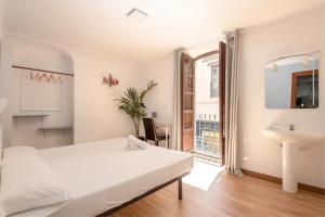 格拉纳达扎卡提尼旅馆的白色卧室设有床铺和水槽