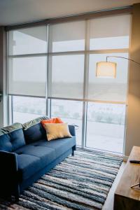 纳什维尔Kasa The Gulch Nashville的客厅设有一张蓝色的沙发,配有大窗户