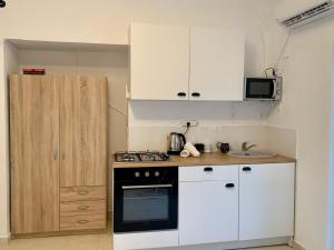 内坦亚Shantell Boutique Apartments的厨房配有白色橱柜和炉灶烤箱。