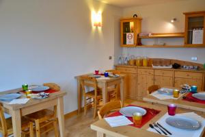 丰多Agritur Fiore的厨房配有木桌和椅子,并备有盘子