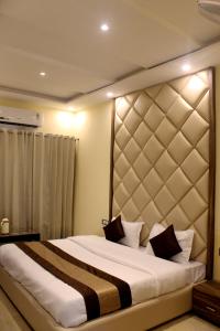 哈里瓦Hotel Ganga Heights的一间卧室配有一张大床和大床头板