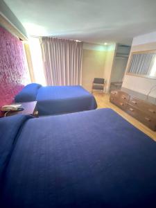萨卡特卡斯Hotel Zacatecas Courts的酒店客房,配有两张带蓝色床单的床