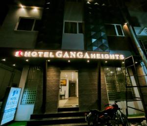 哈里瓦Hotel Ganga Heights的夜间停在大楼前的摩托车