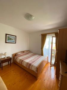 扎布利亚克波波维奇公寓的一间卧室配有一张床、一张桌子和一个窗户。