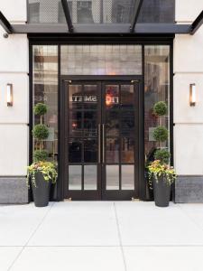 纽约百老汇广场酒店的前方有盆栽植物的商店的玻璃门