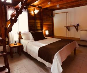 普罗维登西亚Cabañas Agua Dulce的一间带一张大床的卧室,位于一个拥有木制天花板的房间