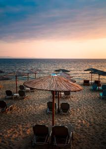 波托什Mr & Mrs K Bianco的海滩上设有椅子和遮阳伞,还有大海