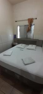 圣保罗Hotel Anacleto的一张大白色的床,位于带镜子的房间里