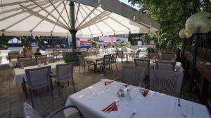 布鲁克安德格罗斯哥Hotel LukasMayr的一间带桌椅和白色遮阳伞的餐厅