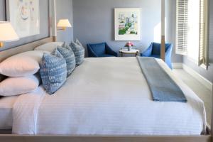 AuroraInns of Aurora Resort & Spa的一张大床,位于带蓝色椅子的房间