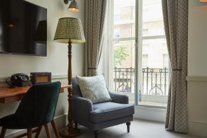 伦敦Lime Tree Hotel的一间带椅子、一盏灯和一扇窗户的房间
