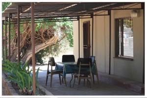 LephalaleAbuelita Guesthouse - Room 1的一个带桌椅和树的庭院
