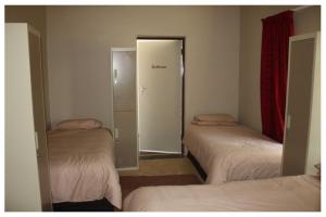 LephalaleAbuelita Guesthouse - Room 4的一间设有三张床的房间和一个通往衣柜的门