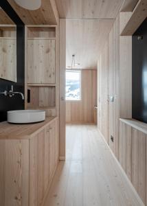 拉维拉Larix Lodge的一间带木墙、水槽和窗户的浴室