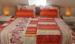 希尔德斯海姆Stadtnahe Komfortferienwohnung für Familien und Geschäftsreisende的一间卧室配有两张带橙色和白色棉被的床