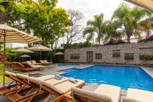 克雷塔罗火烈鸟酒店的一个带躺椅和遮阳伞的游泳池