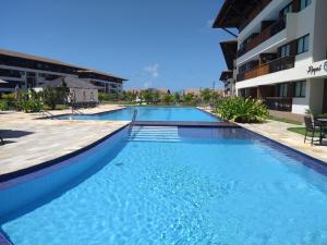 嘎林海斯港Cupe Beach Living Beira Mar - Flat 02 quartos的大楼旁的大型游泳池