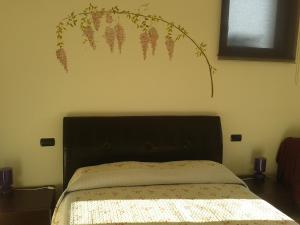 东戈金波顿农家乐的卧室配有一张挂着花壁画的床。