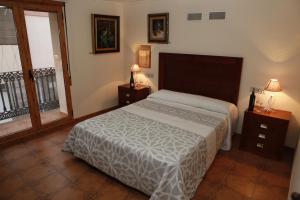比拉法梅斯Casa Rural Magnanimvs的一间卧室设有床、两张桌子和一扇窗户