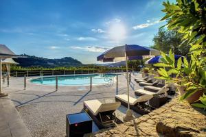 蒙特卡蒂尼泰尔梅Alfresco luxury Villa with Heated pool的一个带躺椅和遮阳伞的游泳池