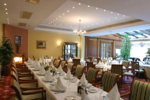 萨格勒布AS酒店的一间设有白色桌椅的用餐室