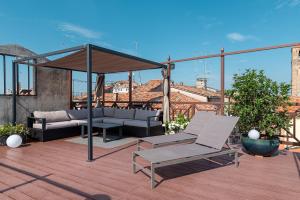 威尼斯La Finestra sulle Beccarie的屋顶上设有一个带沙发和遮阳伞的庭院