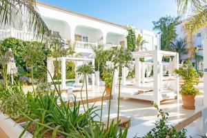 圣安东尼奥湾Beach Star Ibiza的种有植物的庭院和白色的建筑