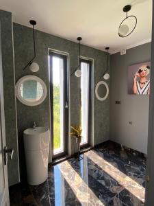 札勒乌NORD APARTAMENTS的带浴缸、水槽和窗户的浴室