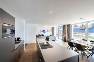 迈尔霍芬MANNI village - lifestyle apartments的厨房以及带桌椅的起居室。