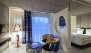 基尔维莱梦之迷你套房旅馆的一间卧室配有一张床、一个窗口和椅子