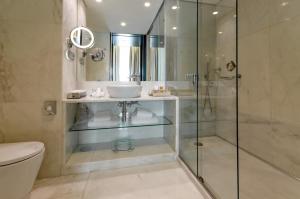 里斯本圣塔胡斯塔酒店的一间带玻璃淋浴和水槽的浴室