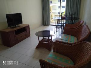 邦咯Pangkor fun fun fun apartment的客厅配有椅子、电视和桌子