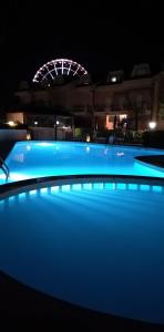 利多迪耶索罗B&C Apartments LA POSTA Home的夜间游泳池,后面有摩天轮