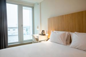 马亚Stay Hotel Porto Aeroporto的卧室配有一张大白色的床和书桌