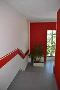 莱比锡阿斯特拉尔茵莱比锡酒店与餐厅的走廊上设有红色的墙壁和盆栽植物