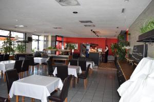 莱比锡阿斯特拉尔茵莱比锡酒店与餐厅的一间带白色桌椅的餐厅和一间厨房