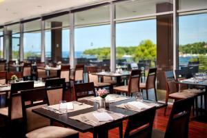 波雷奇Hotel Molindrio Plava Laguna的餐厅设有桌椅和窗户。